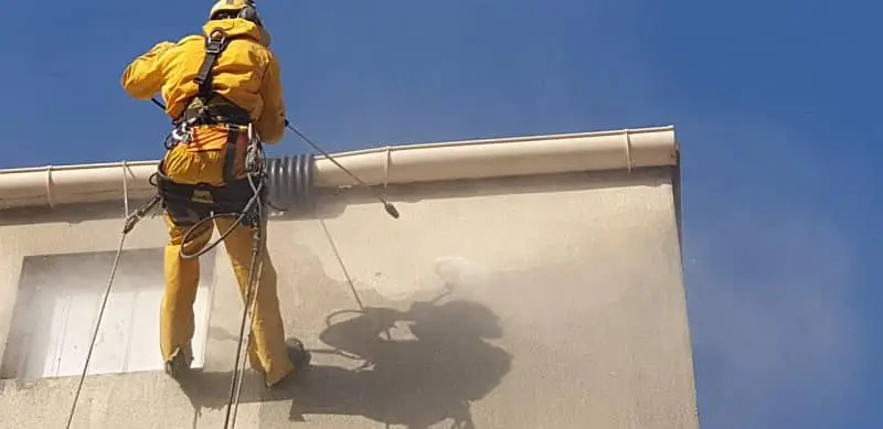 lavage haute pression d'une façade par 2 cordistes de l'équipe de Marseille