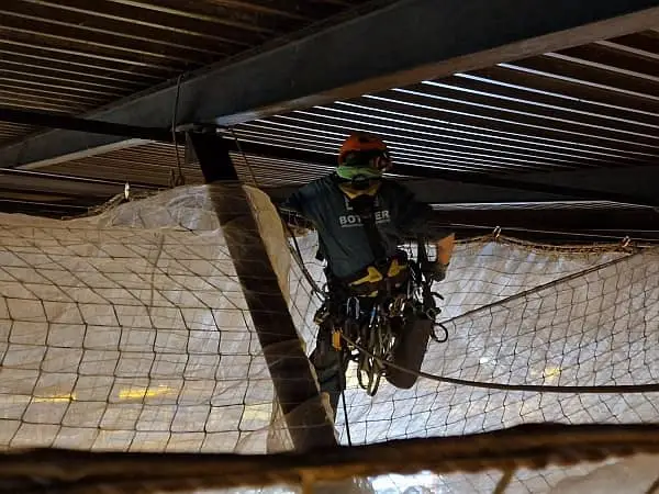 Cordiste de Marseille posant des filets de sécurité EN1263-1 en hauteur