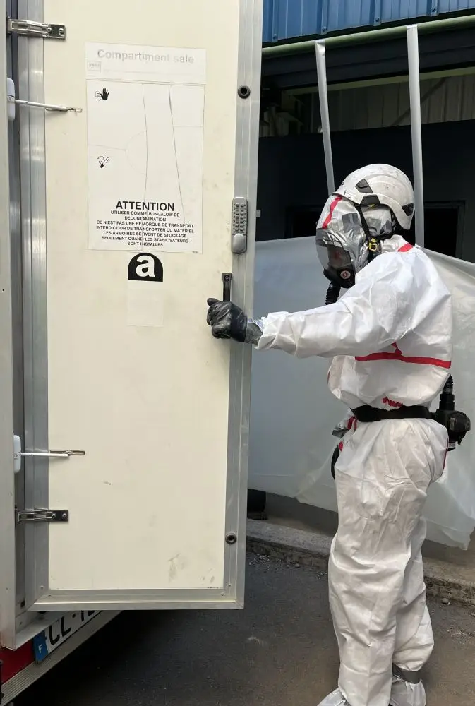 Technicien cordiste de BOTHIER entrant dans une Unité Mobile de Décontamination amiante