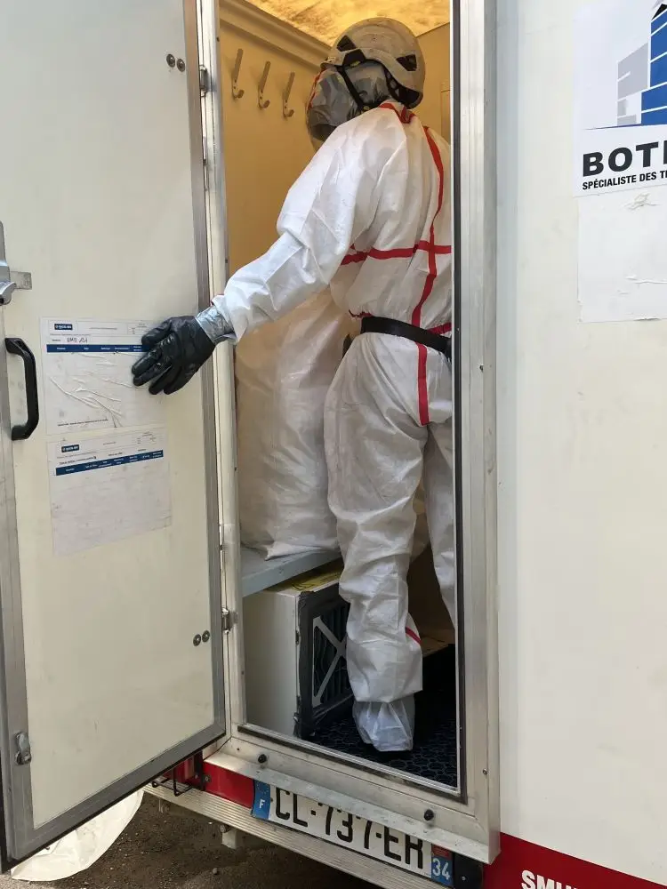 Technicien cordiste de BOTHIER entrant dans une Unité Mobile de Décontamination amiante