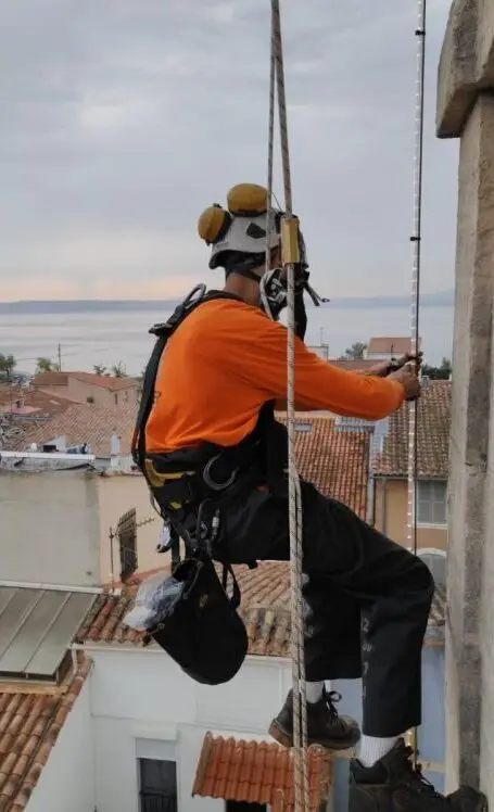 Cordiste posant des luminaires en hauteur sur une église à Martigues dans les Bouches-du-Rhône, 13